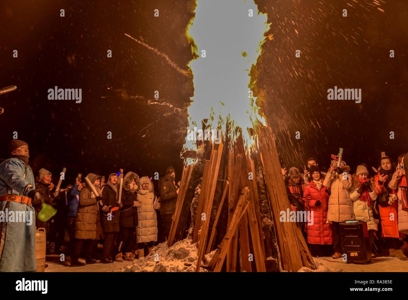 Kanas, China Autonome Region Xinjiang Uygur. 31 Dez, 2018. Touristen jubeln an einem Lagerfeuer Gala an Silvester in Hemu Dorf Kanas, Nordwesten Chinas Autonome Region Xinjiang Uygur, 31.12.2018. Tourismus im Winter der Schnee Resort der Hemu im Altai Region ist dank der Verbesserung der Transport- und Heizung im Winter Versorgung im Bereich revitalisiert. Credit: Zhao Ge/Xinhua/Alamy leben Nachrichten Stockfoto