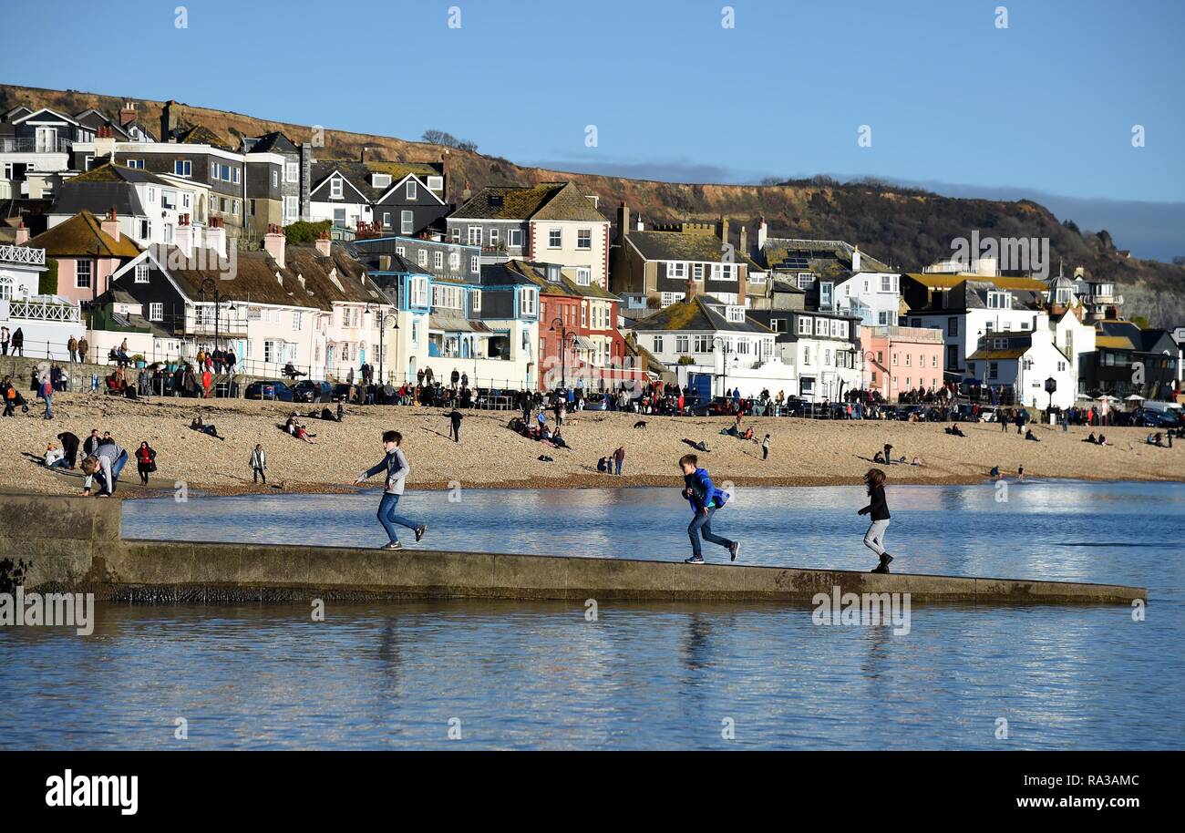 Lyme Regis, Dorset. 1. Jan 2019. UK Wetter: Menschen genießen Sie die warme und sonnige Wetter in Lyme Regis, Dorset Credit: Finnbarr Webster/Alamy leben Nachrichten Stockfoto