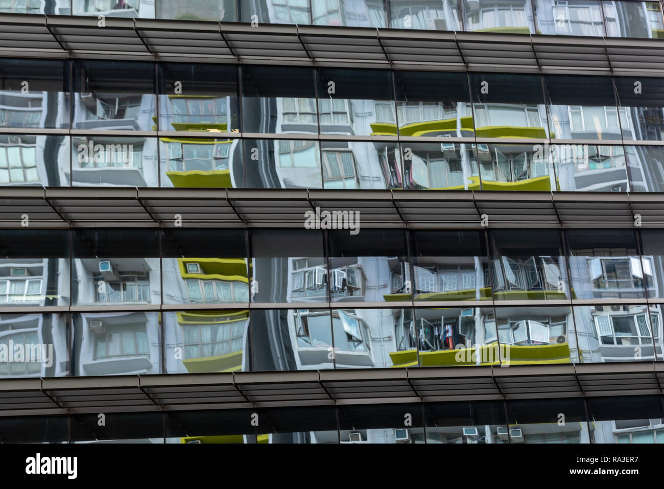 Lebens wider: die Fenster eines traditionellen Wan Chai Apartment Block in dem Spiegel reflektiert - wie Vorhangfassade eines neuen Bausteins Stockfoto