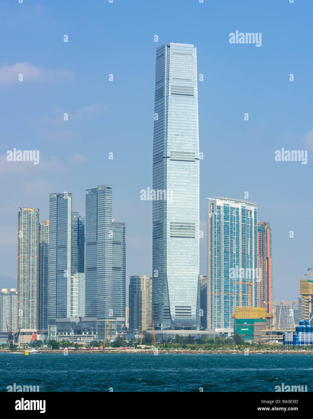 Hong Kong's höchste Gebäude, das International Commerce Centre, glitzert in der Sonne, denn es ragt über den Victoria Harbour Stockfoto