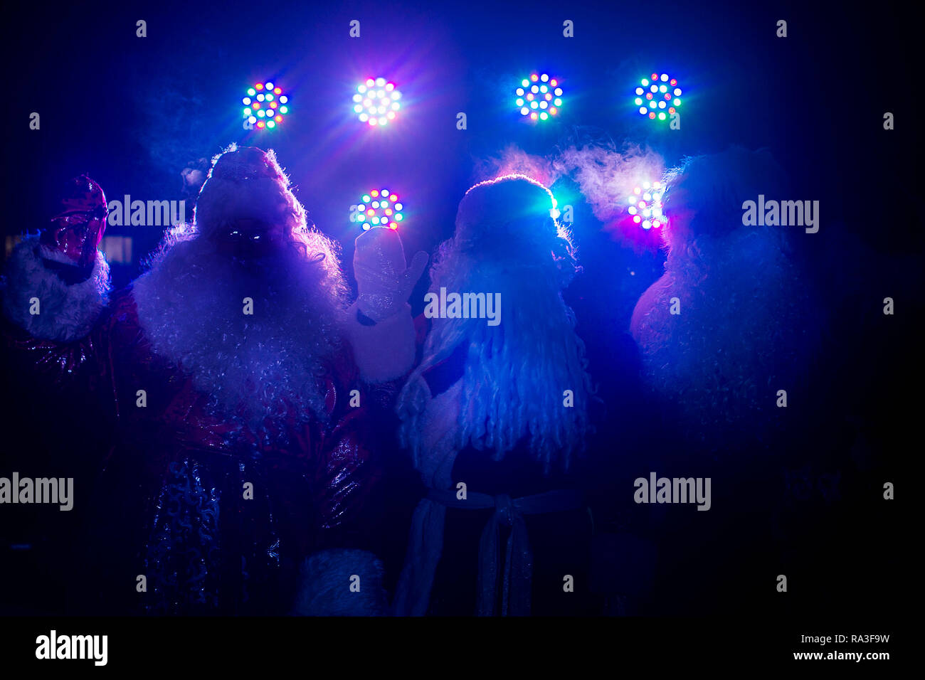 Drei glückliche senior Santa Claus Zahlen im Licht der Lampen Stockfoto