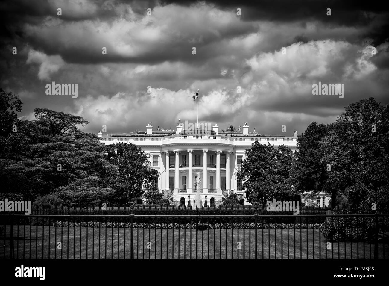 Düsterer Schwarz-Weiß-Sicht auf das Weiße Haus mit Gewitterwolken über dem South Lawn in Washington DC, USA brauen Stockfoto