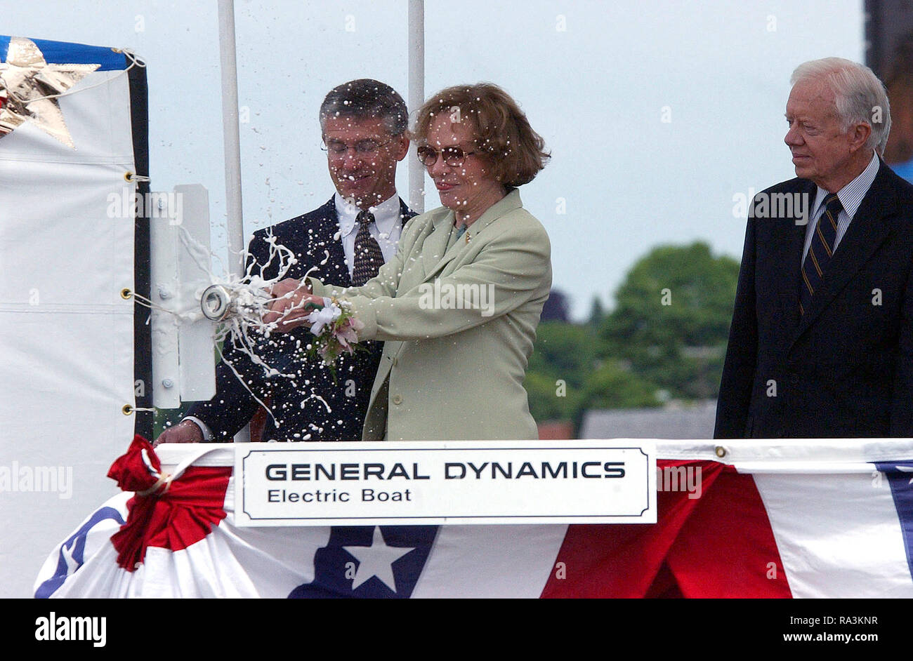 Ehemalige First Lady Rosalynn Carter zertrümmert, eine Flasche Champagner gegen das Segel der US Navy (USN) SEAWOLF CLASS: Angriffs-U-Boot, die USS Jimmy Carter (SSN 23), während das Schiff Taufe, gehalten an der elektrische Boot Corporation von Connecticut, in Groton, Connecticut (CT). Auch dargestellt sind: Herr John S. Casey (links), Präsident, Elektroboot Division, und der ehemalige US-Präsident Jimmy Carter, Namensgeber des Schiffes. Stockfoto