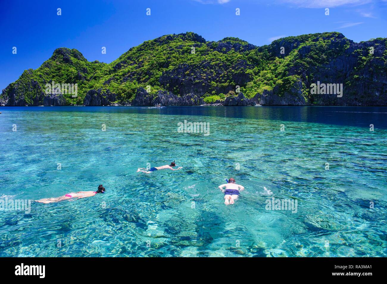 Touristen schnorcheln im kristallklaren Wasser in der Bacuit Archipel, Palawan, Philippinen Stockfoto