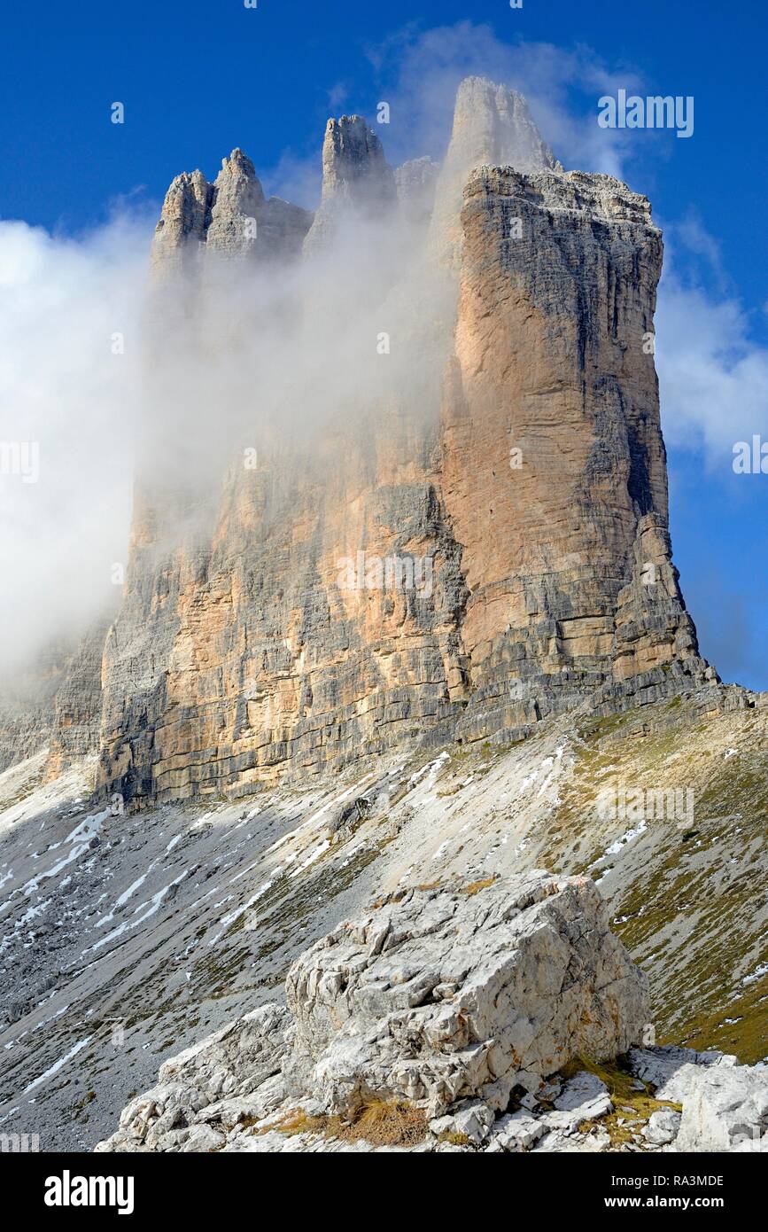 Drei Zinnen von Lavaredo Süden Wände durch tiefe Wolken, blauer Himmel bedeckt, Sextner Dolomiten, Provinz Südtirol Alto-Adige, Italien Stockfoto