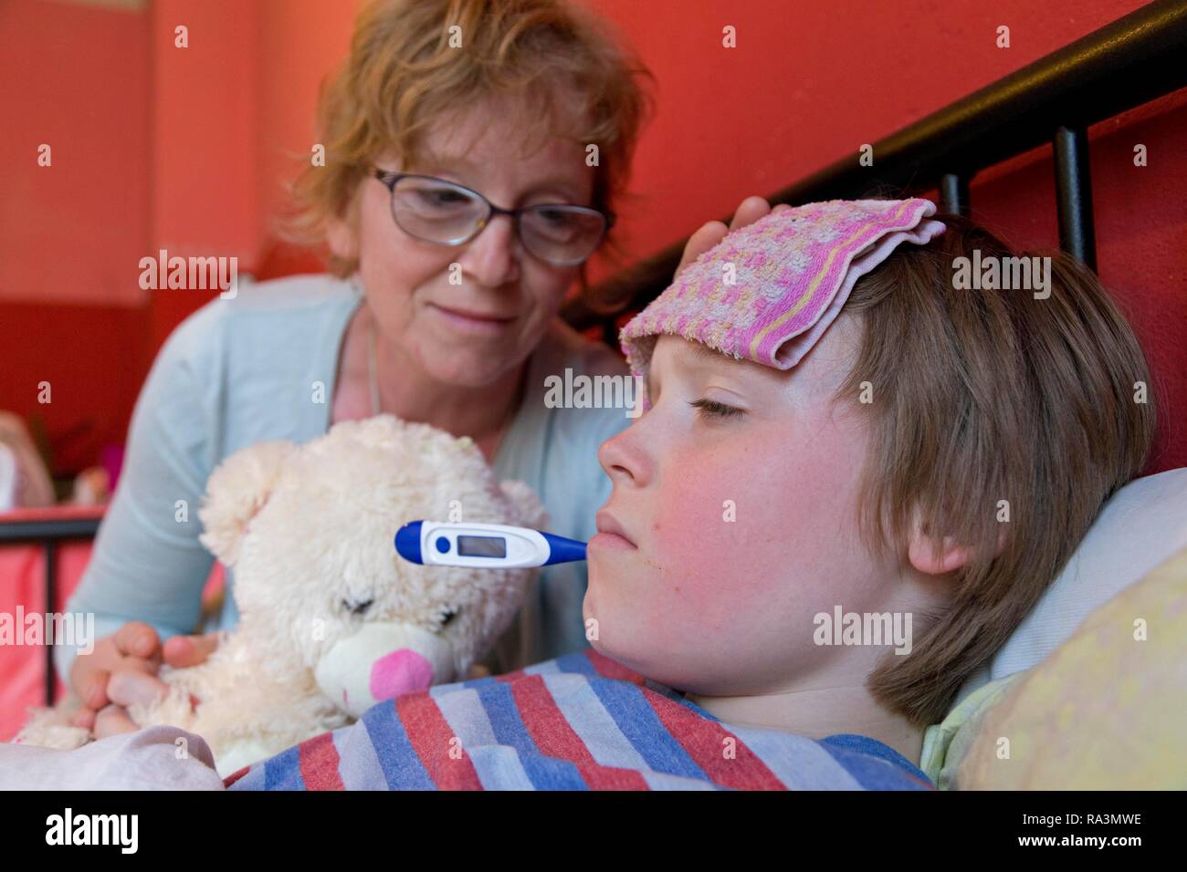 Mutter Komfort kranken Sohn im Bett, Symbol, Bild, kalt, Pflege, Eltern, Kindheit, Deutschland Stockfoto