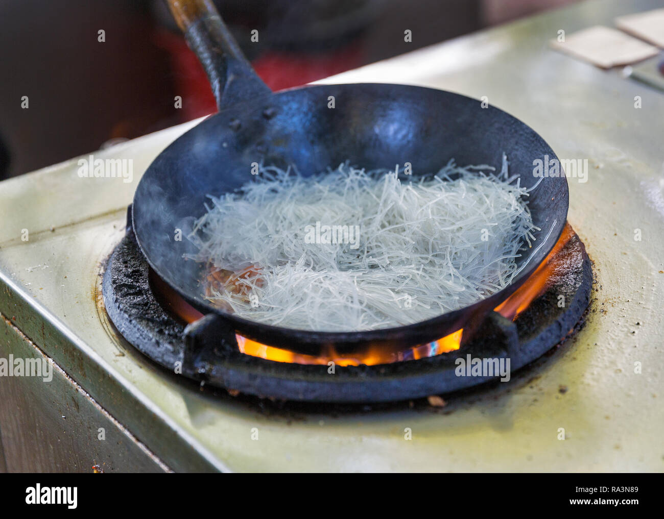 Kochen im Freien asiatische Speisen in einem Wok auf dem Gasherd closeup Stockfoto