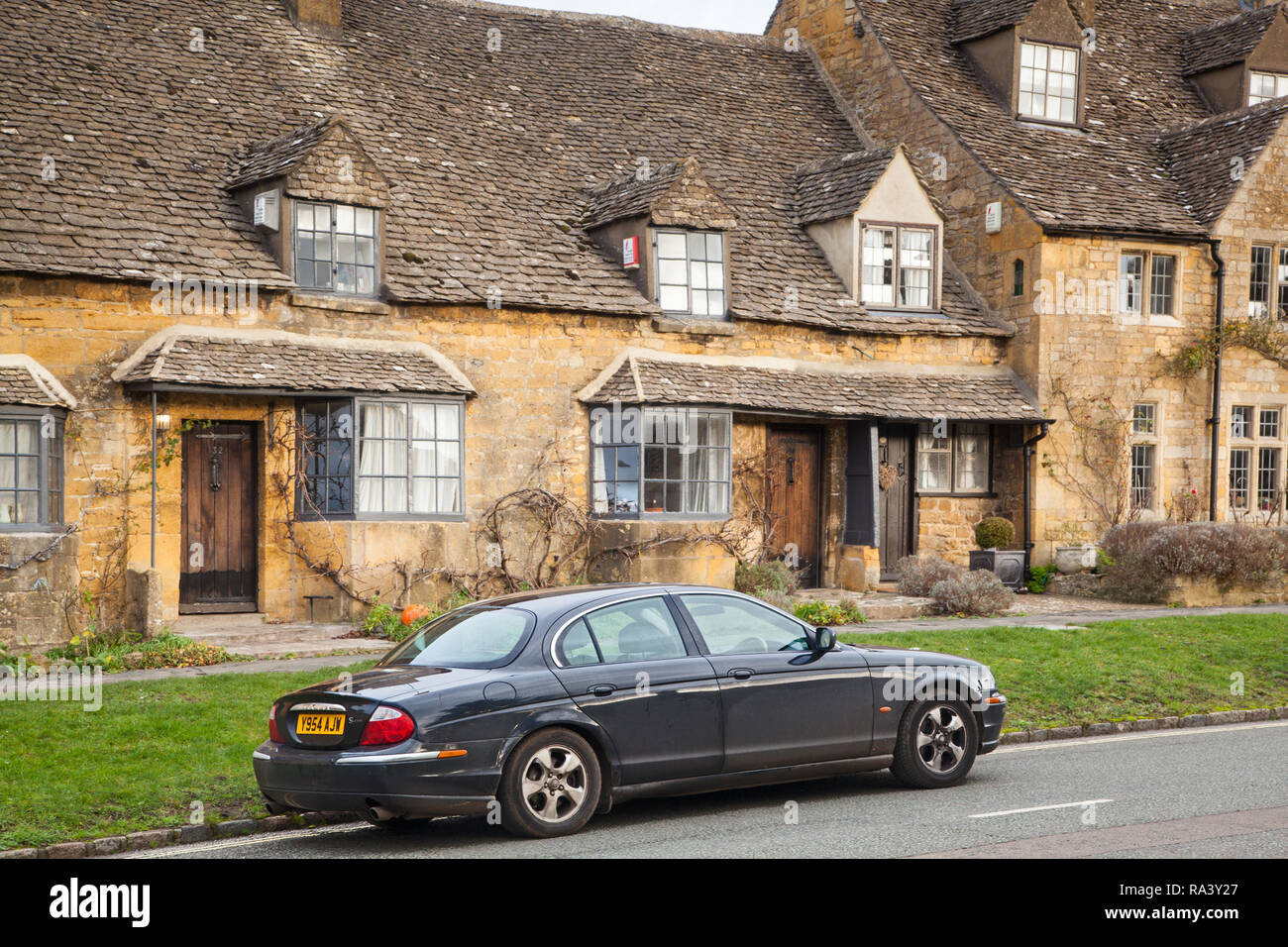 Jaguar S type Pkw im malerischen Dorf Cotswold schlechthin der Broadway mit seinen Cotswold stone Gebäude und Häuser geparkt Stockfoto