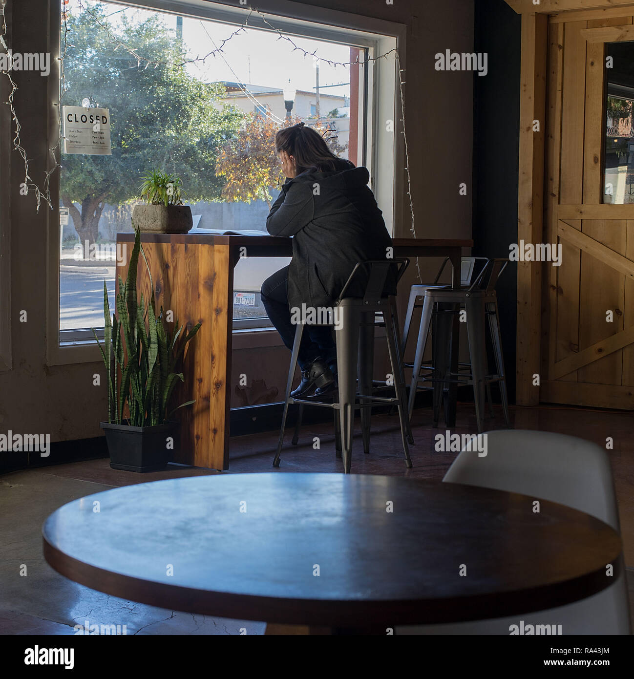Frau in einem Coffee Shop Schauen durch ein Fenster Stockfoto