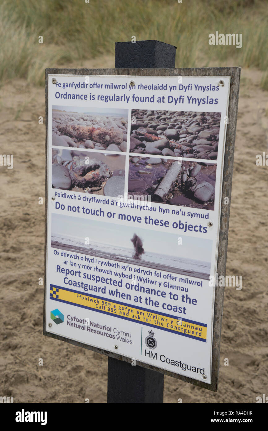Zweisprachige Welsh-English Zeichen Warnung durch nicht detonierte Sprengkörper auf dem Strand in ynyslas am Dyfi Mündung, in der Nähe von Borth und Aberystwyth, Ceredigion, Wales, Stockfoto