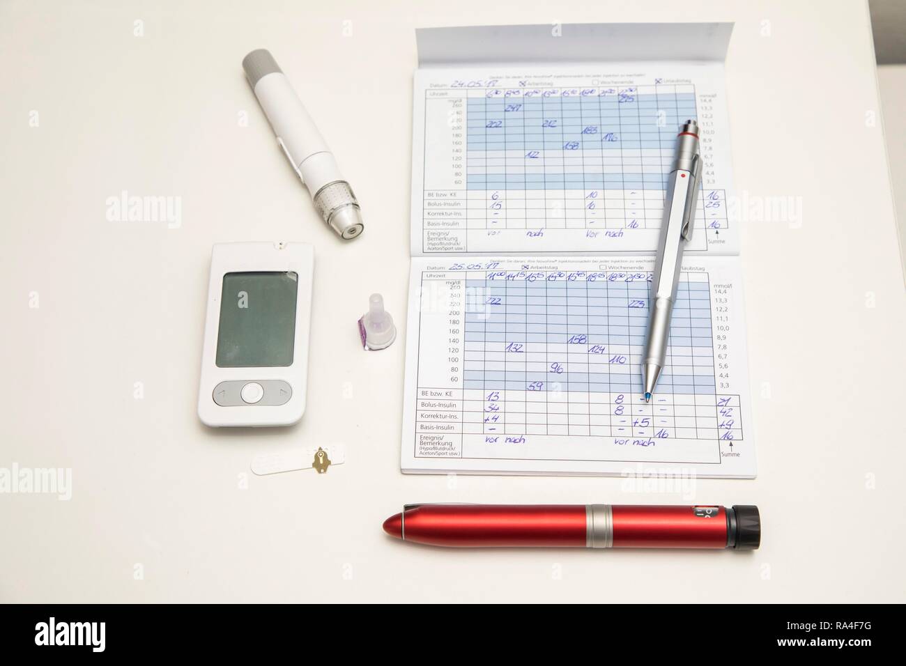 Diabetes, links Blutzuckermessgeräte, Teststreifen und Stechhilfe, Insulinpen, Blutglukose Tagebuch, Deutschland Stockfoto