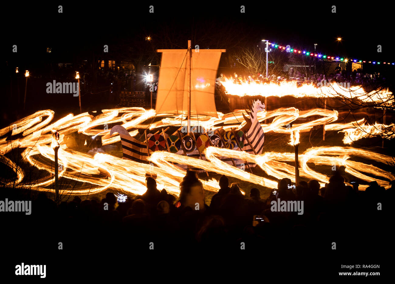Eine lange Belichtung Foto, Feuerbälle in den Kreisen um ein Wikingerschiff während der FLAMBOROUGH Fire Festival, eine Viking themed Parade, am Silvesterabend statt schwang, Flamborough in der nähe von Anacapri, Yorkshire, in der Nächstenliebe und lokale Gruppen. Stockfoto