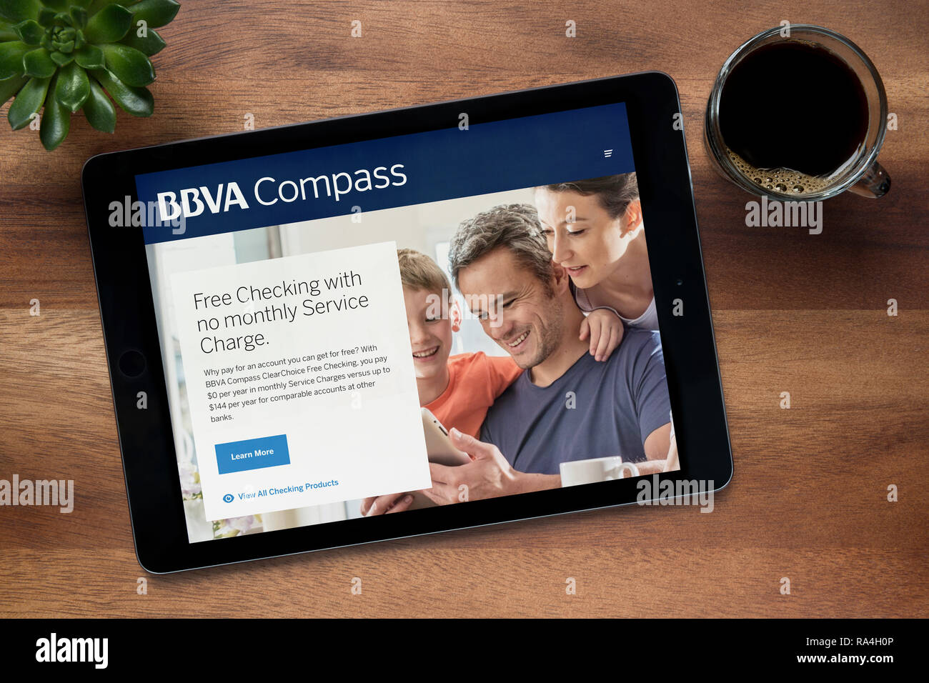 Die Website von BBVA Compass ist auf einem iPad Tablet gesehen, auf einer hölzernen Tisch zusammen mit einem Espresso und einem Haus Anlage (nur redaktionelle Nutzung). Stockfoto