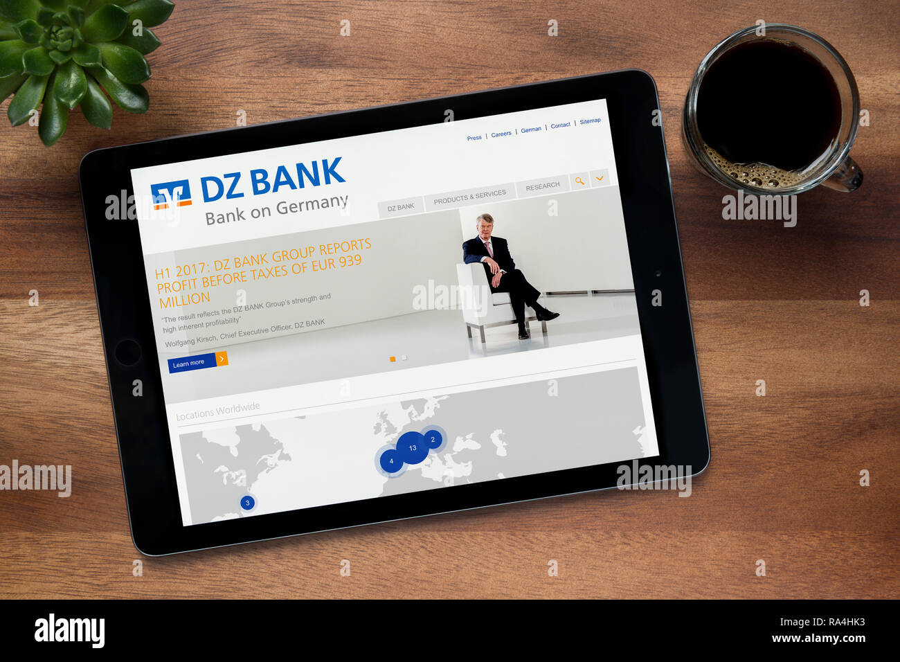 Auf der Website der DZ Bank ist auf einem iPad Tablet gesehen, auf einer hölzernen Tisch zusammen mit einem Espresso und einem Haus Anlage (nur redaktionelle Nutzung). Stockfoto