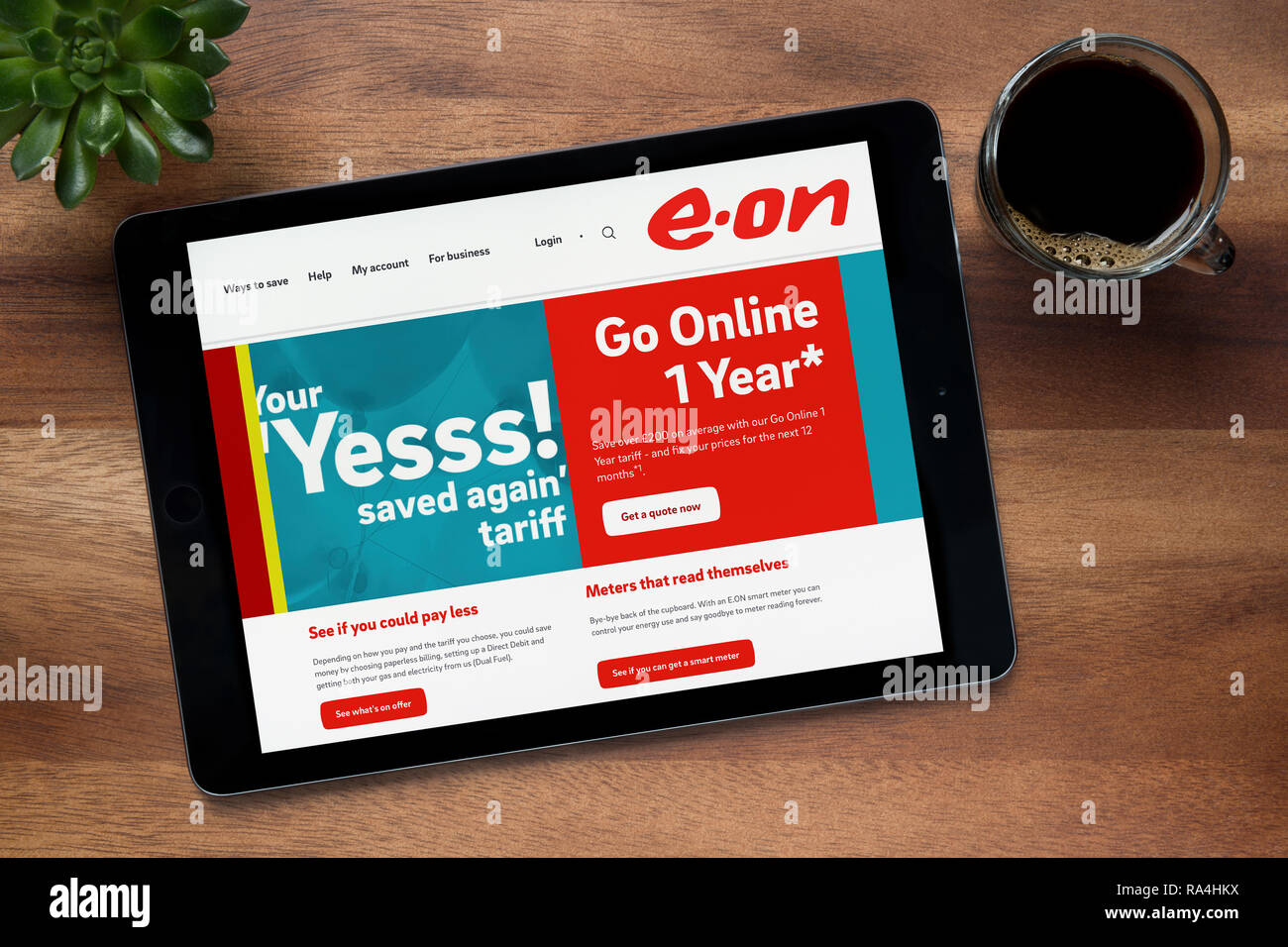 Die Website von E.ON ist auf einem iPad Tablet gesehen, auf einer hölzernen Tisch zusammen mit einem Espresso und einem Haus Anlage (nur redaktionelle Nutzung). Stockfoto