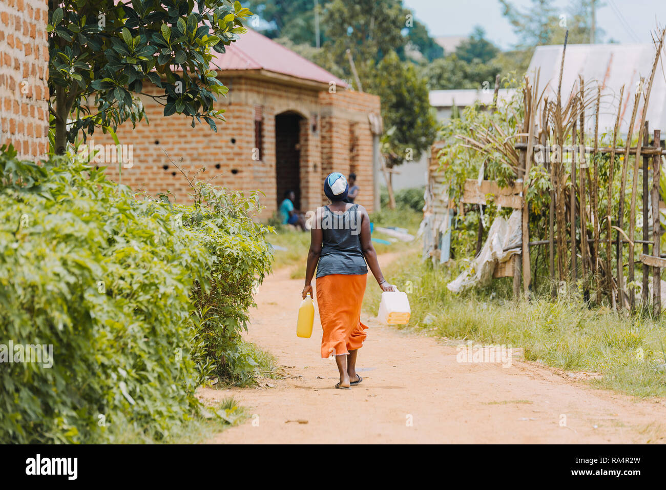 Frau, die Wasser in Entebbe, Uganda, trägt Stockfoto
