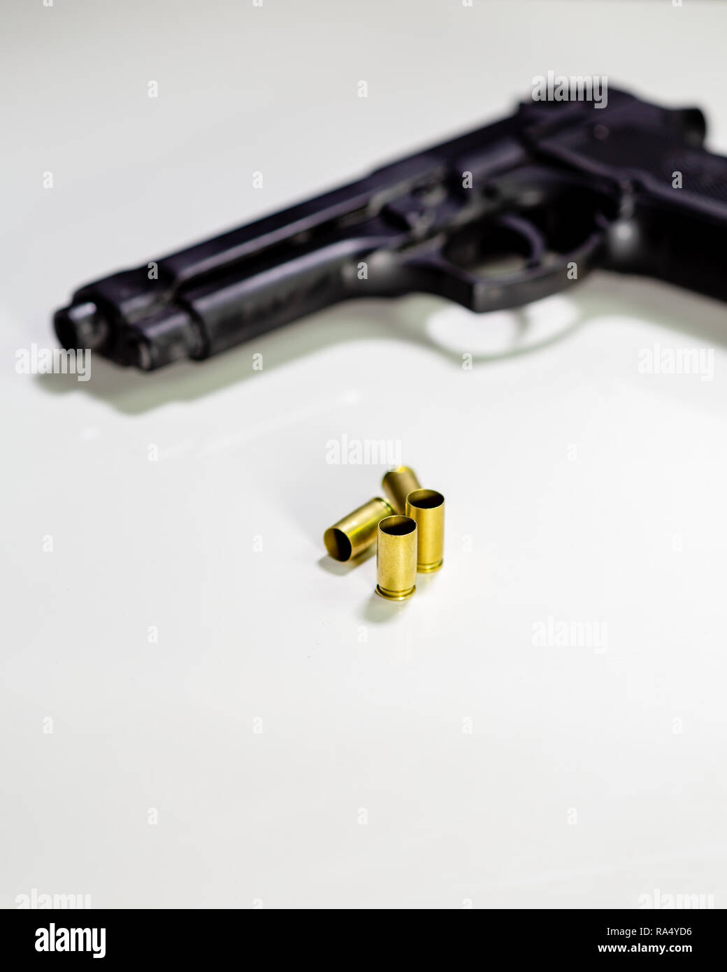 Pistole mit 9-mm-Patronenhülsen auf weißen Tisch Stockfoto