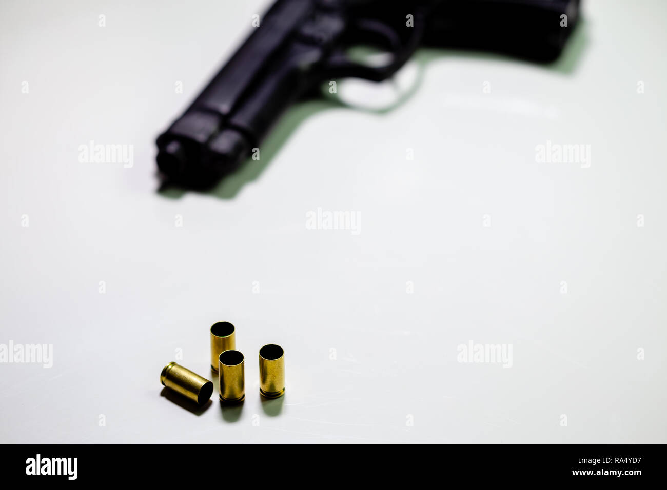 Pistole mit 9-mm-Patronenhülsen auf weißen Tisch Stockfoto