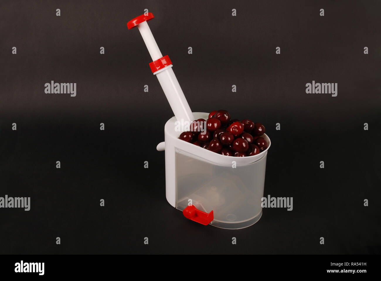 Küche Gerät für Extrakte Knochen von Cherry Beeren auf schwarzen Hintergrund mit weichen Schatten isoliert Stockfoto