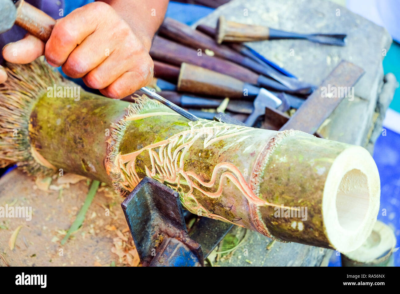 Thailndische Handwerker nutzt Meiel zu schnitzen Bambus Muster, Carving  ist eine der vererbten Kenntnisse des thailndischen Volkes Stockfotografie  - Alamy