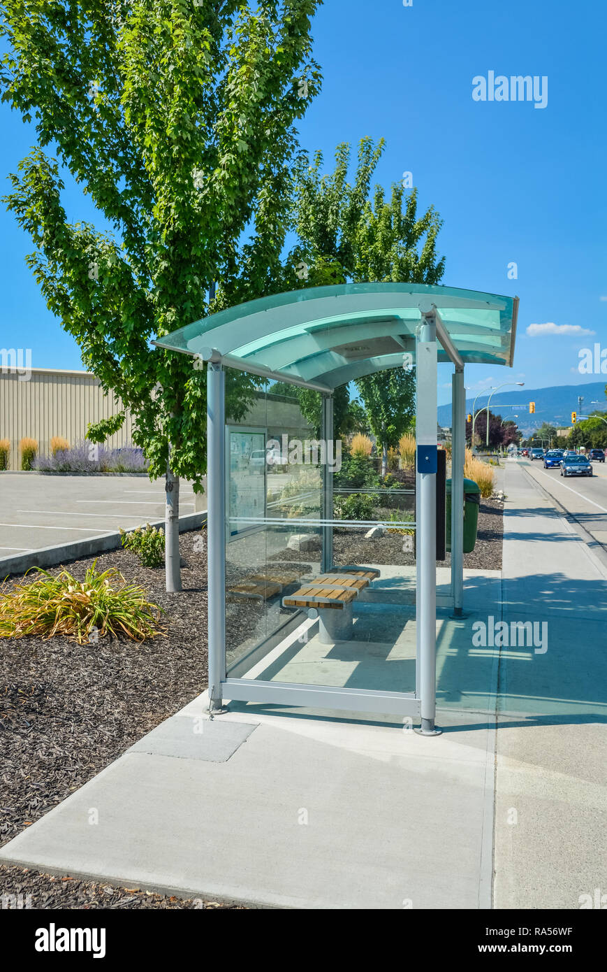 Transparente Bushaltestelle am Straßenrand an einem sonnigen Tag in British Columbia. Stockfoto