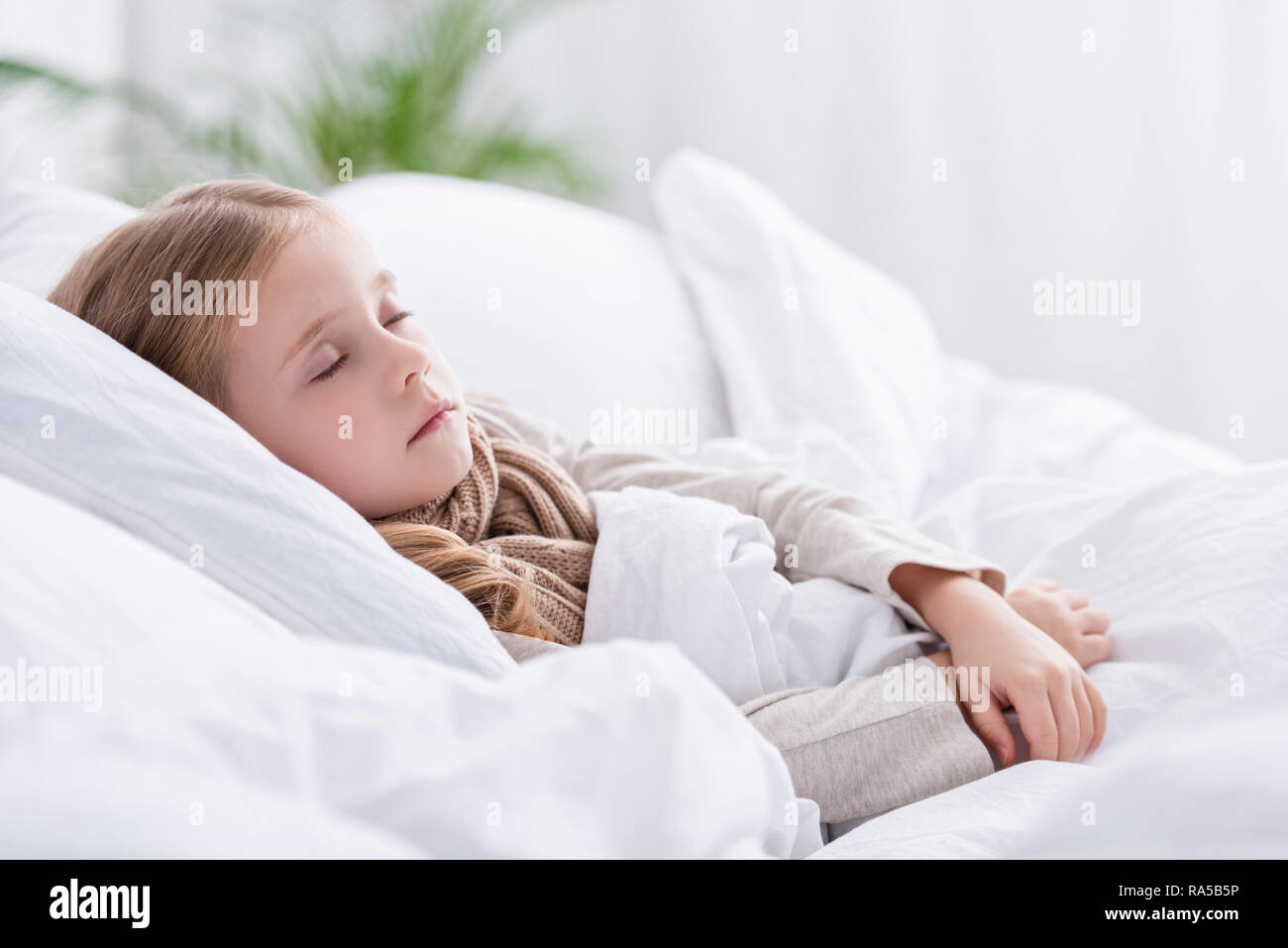 Krankes Kind mit Schal über Hals schlafen im Bett zu Hause Stockfotografie  - Alamy