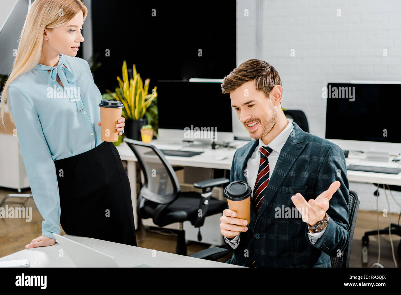 Junge Kollegen mit Kaffee zu gehen, Gespräch im Büro Stockfoto