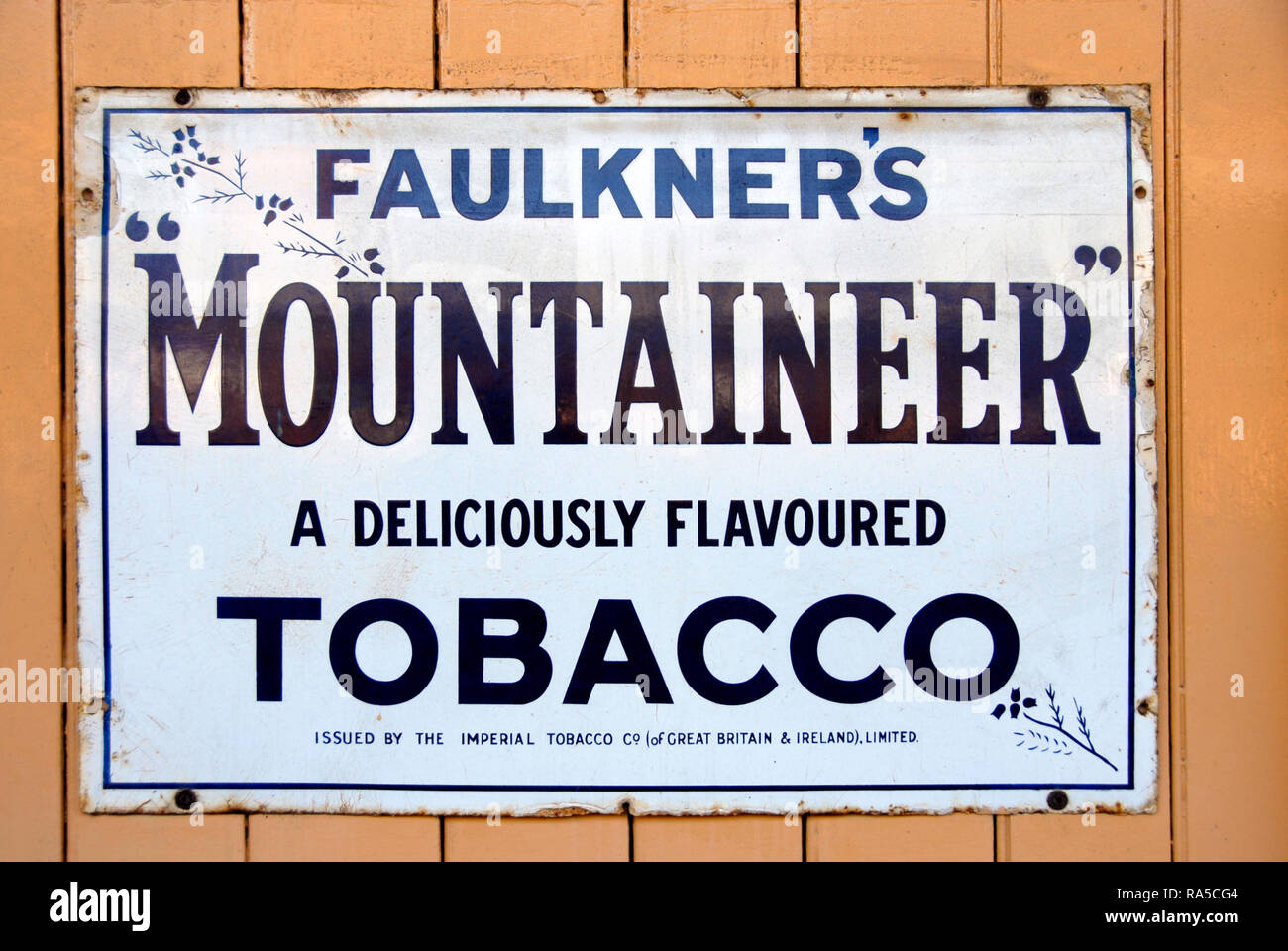 Alte Metall Werbefläche für Faulkener's Bergsteiger Tabak auf der Wand am Bahnhof, England Stockfoto
