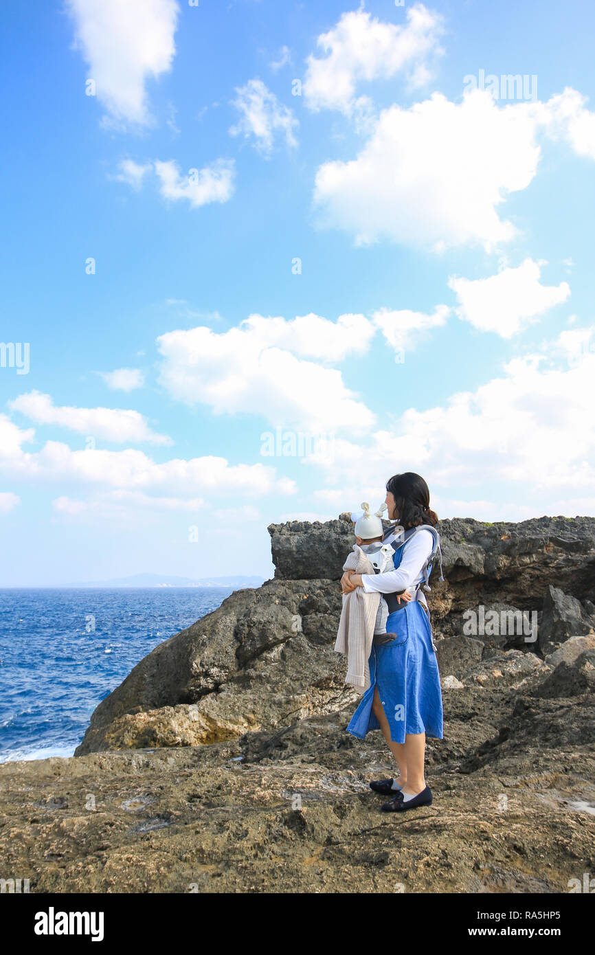 Asiatische Mutter mit ihrem Baby am Kap Zanpa Okinawa Japan Stockfoto