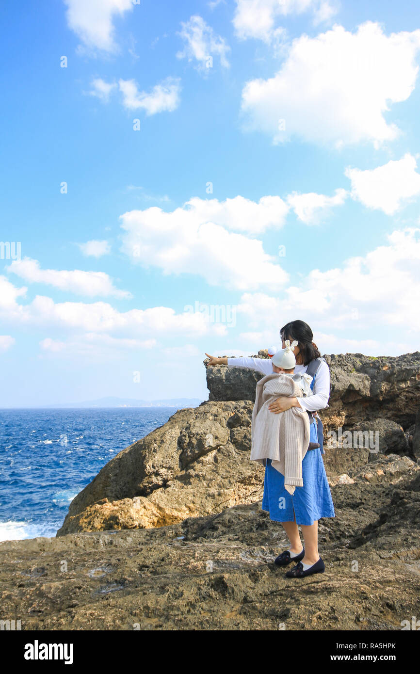 Asiatische Mutter mit ihrem Baby am Kap Zanpa Okinawa Japan Stockfoto