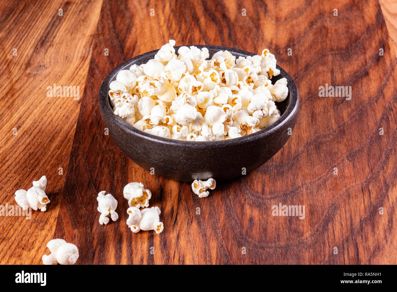 Salz Popcorn auf dem Holztisch. Popcorn in eine Schüssel geben. Einen Film mit Popcorn. Kopieren Sie Platz. Pop Corn. Stockfoto