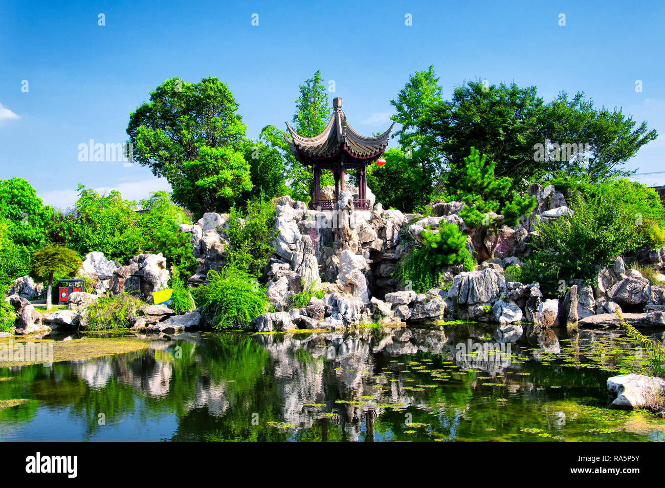 Ein Chinesischer Pavillon und künstlichen Teich innerhalb der alten Stadt Luzhi Scenic Area in Wuzhong China in der Provinz Jiangsu auf einem sonnigen blauen Himmel. Stockfoto