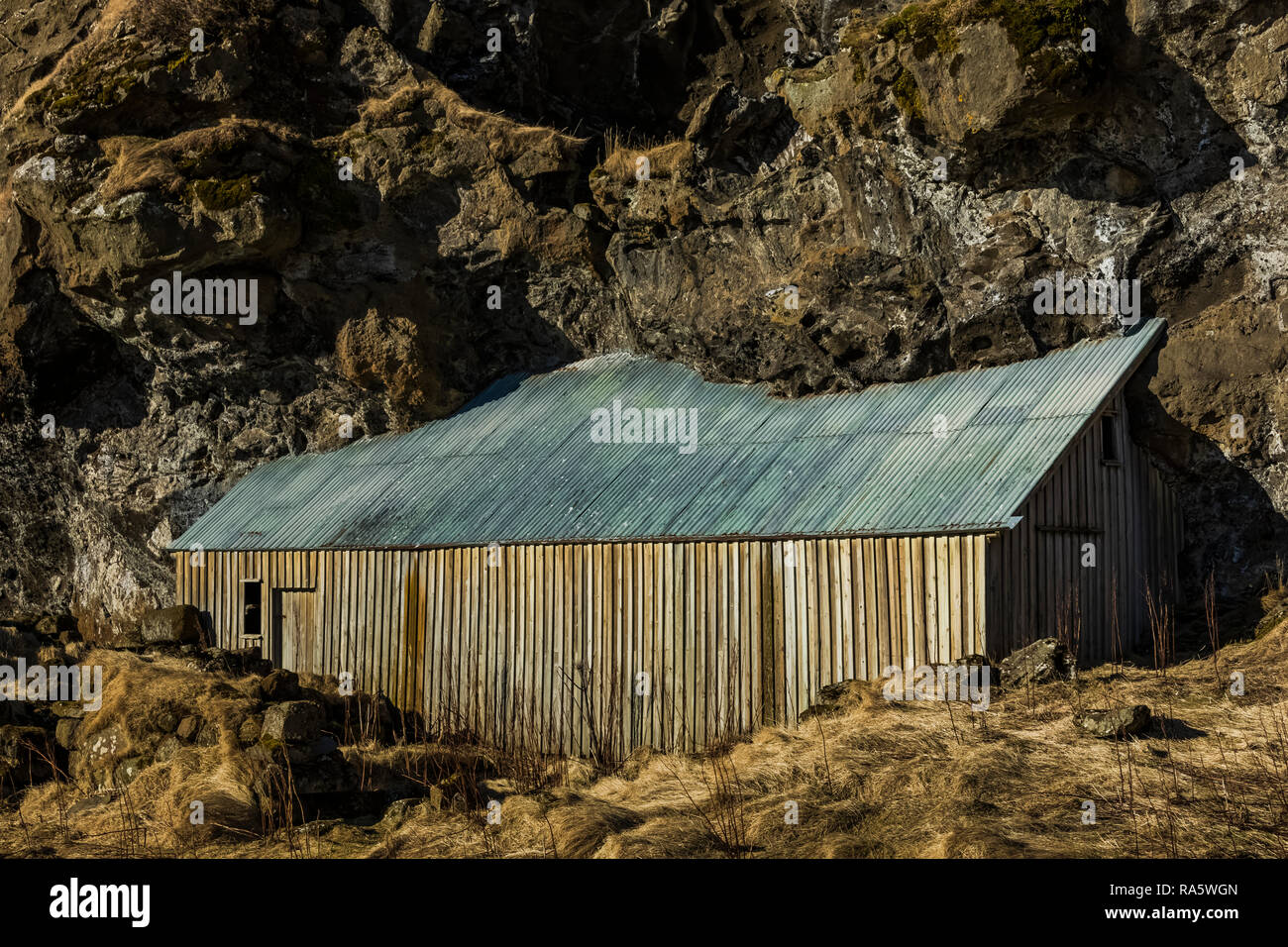 Holz Stall mit Metall Dach in Drangurinn Felsen gebaut, sprach zu Hause zu Elfen, an Drangshlíð 2 entlang der südlichen Küste von Island. Stockfoto