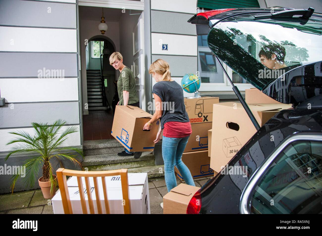 Privater Umzug, Freunde helfen ein Auto zu entladen Stockfoto