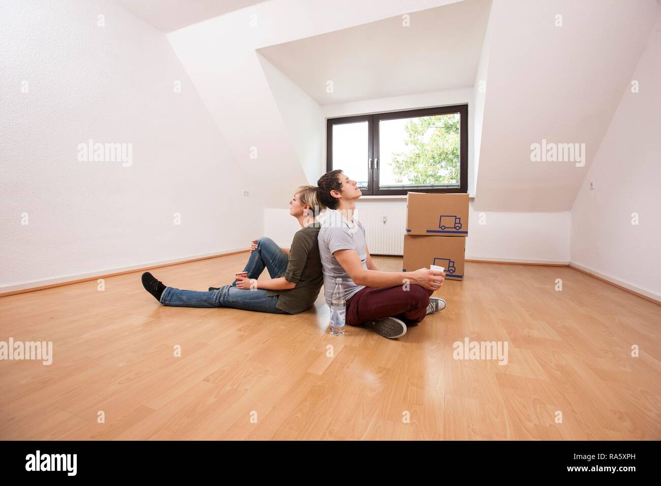 Junges Paar mit beweglichen Kästen in der leeren Wohnzimmer in eine neue Wohnung Stockfoto