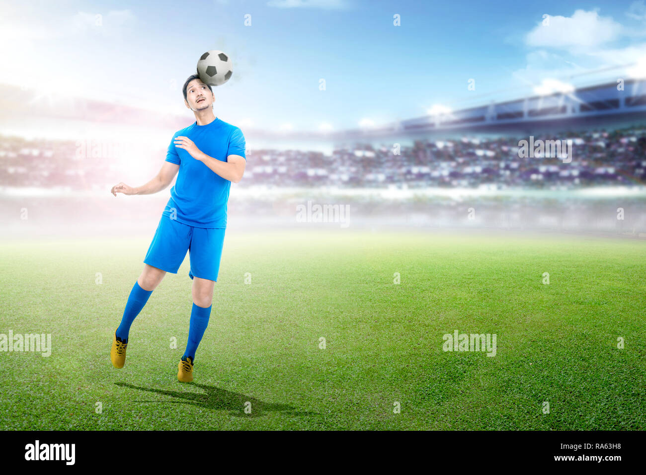 Jungen asiatischen Fußball-Spieler Rubrik Kugel auf Stadion Hintergrund Stockfoto