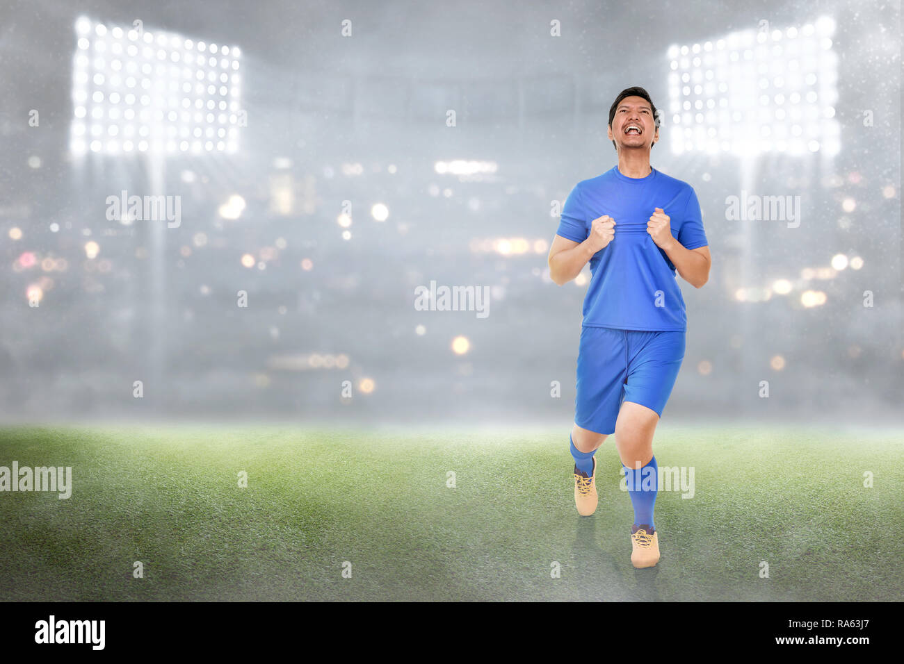 Gerne asiatische Fußball-Spieler feiern seine Tore im Spiel Stockfoto