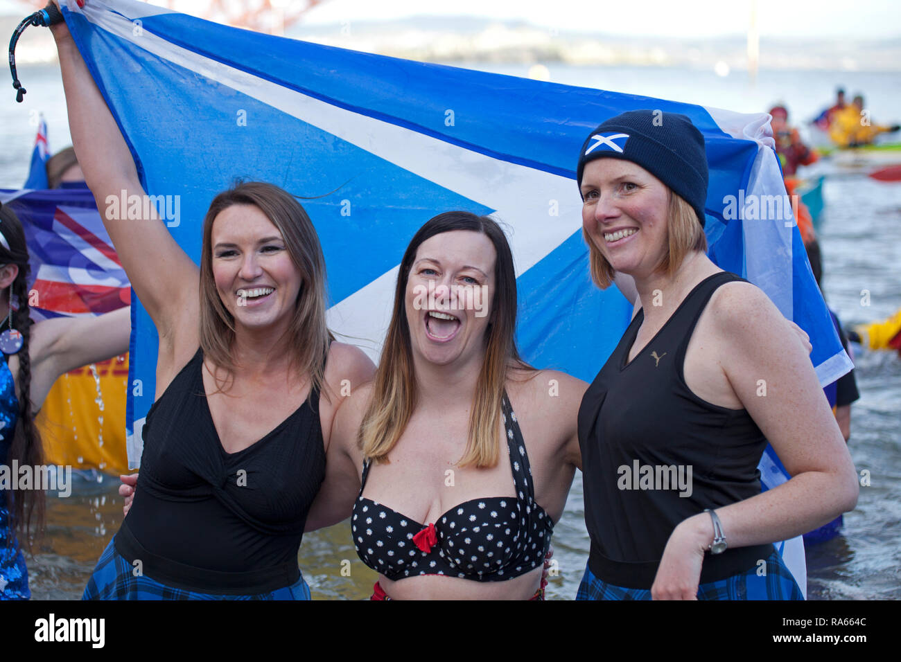 South Queensferry, Edinburgh, Schottland, Großbritannien. 01. Januar 2019. Queensferry neues Jahr Loony Dook, die jährlichen Bad im Firth von weiter im Schatten der weltberühmten Forth Rail Bridge. Erfolgt am dritten Tag der Edinburgh Hogmany ins neue Jahr feiern. Maximale Kapazität Massen Stockfoto