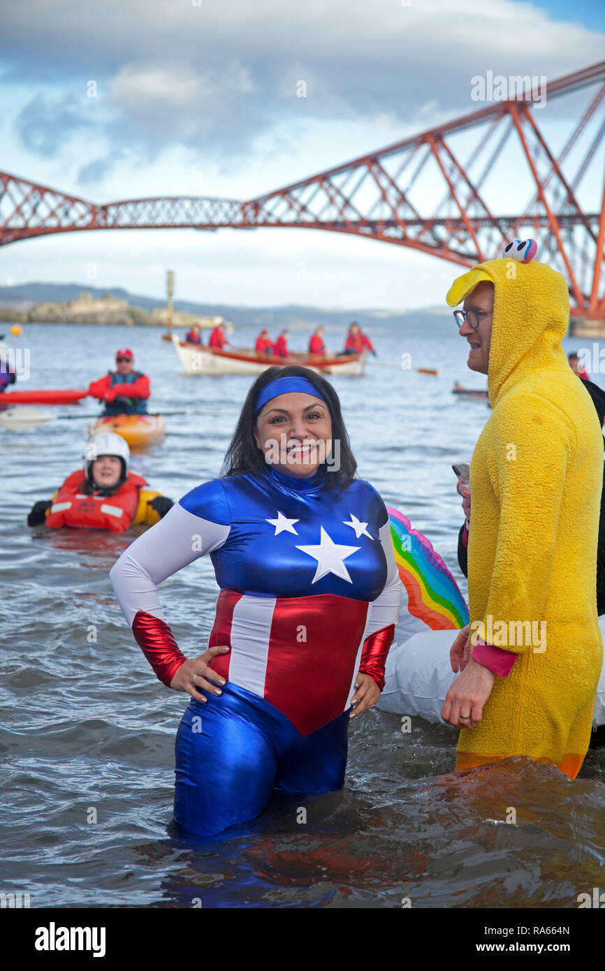 South Queensferry, Edinburgh, Schottland, Großbritannien. 01. Januar 2019. Queensferry neues Jahr Loony Dook, die jährlichen Bad im Firth von weiter im Schatten der weltberühmten Forth Rail Bridge. Erfolgt am dritten Tag der Edinburgh Hogmany ins neue Jahr feiern. Maximale Kapazität Masse Stockfoto