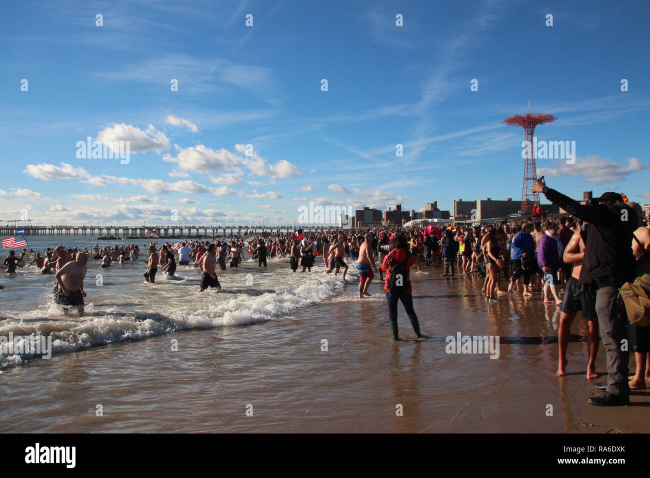 New York, USA. 01 Jan, 2019. Mehrere tausend Menschen in den kalten Atlantik während des traditionellen Silvester am Strand vor dem Vergnügungspark auf Coney Island in Brooklyn Bezirk schwimmen. Jedes Jahr tausende von Menschen in der so genannten Eisbär stürzen. Credit: Christina Horsten/dpa/Alamy leben Nachrichten Stockfoto