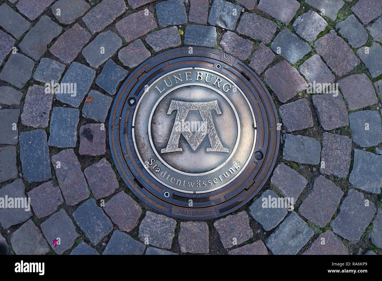 Kanaldeckel mit dem Symbol für die Formel Mons, Pons, Fons: Berg, Brücke, Quelle, Lüneburg, Niedersachsen, Deutschland Stockfoto