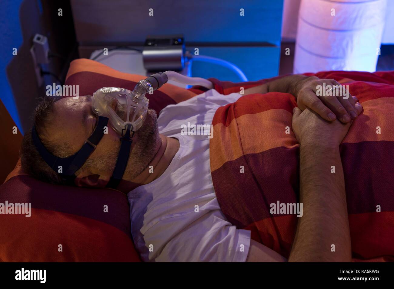 Menschen mit Schlafapnoe Syndrom, trägt eine CPAP-Maske beim Schlafen, Atemmaske, die Luft in die Atemwege drückt durch Stockfoto