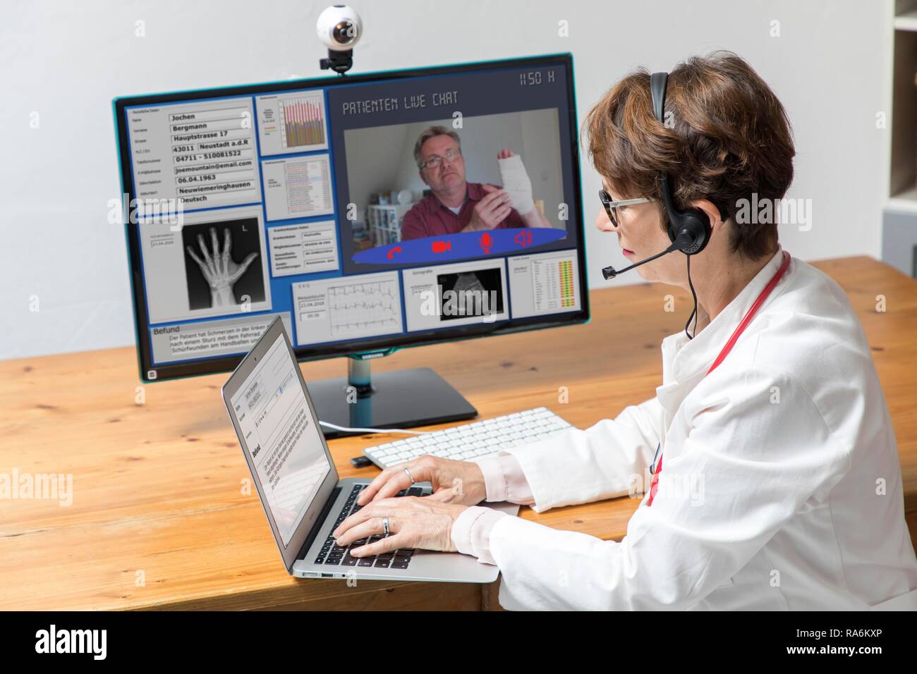 Symbol Foto für Telemedizin, Arzt in einer Praxis, kommuniziert mit dem Patienten über eine Webcam, Patientendaten und Befunde auf Stockfoto