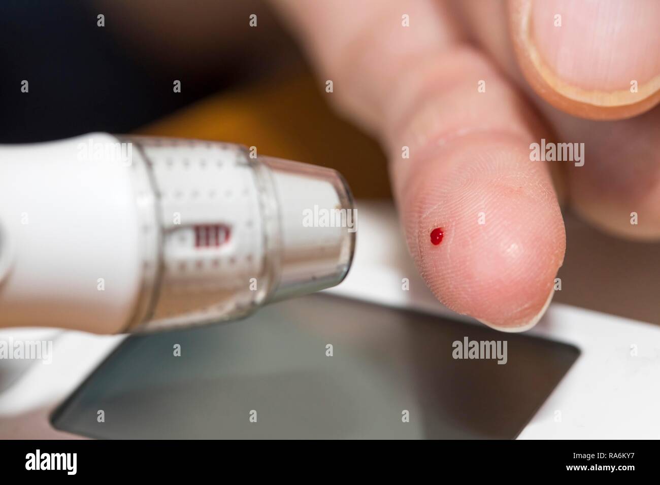 Diabetiker ein Blutglukosetest, mit einer Stechhilfe ein Tropfen Blut an der Fingerspitze produziert wird, Deutschland Stockfoto