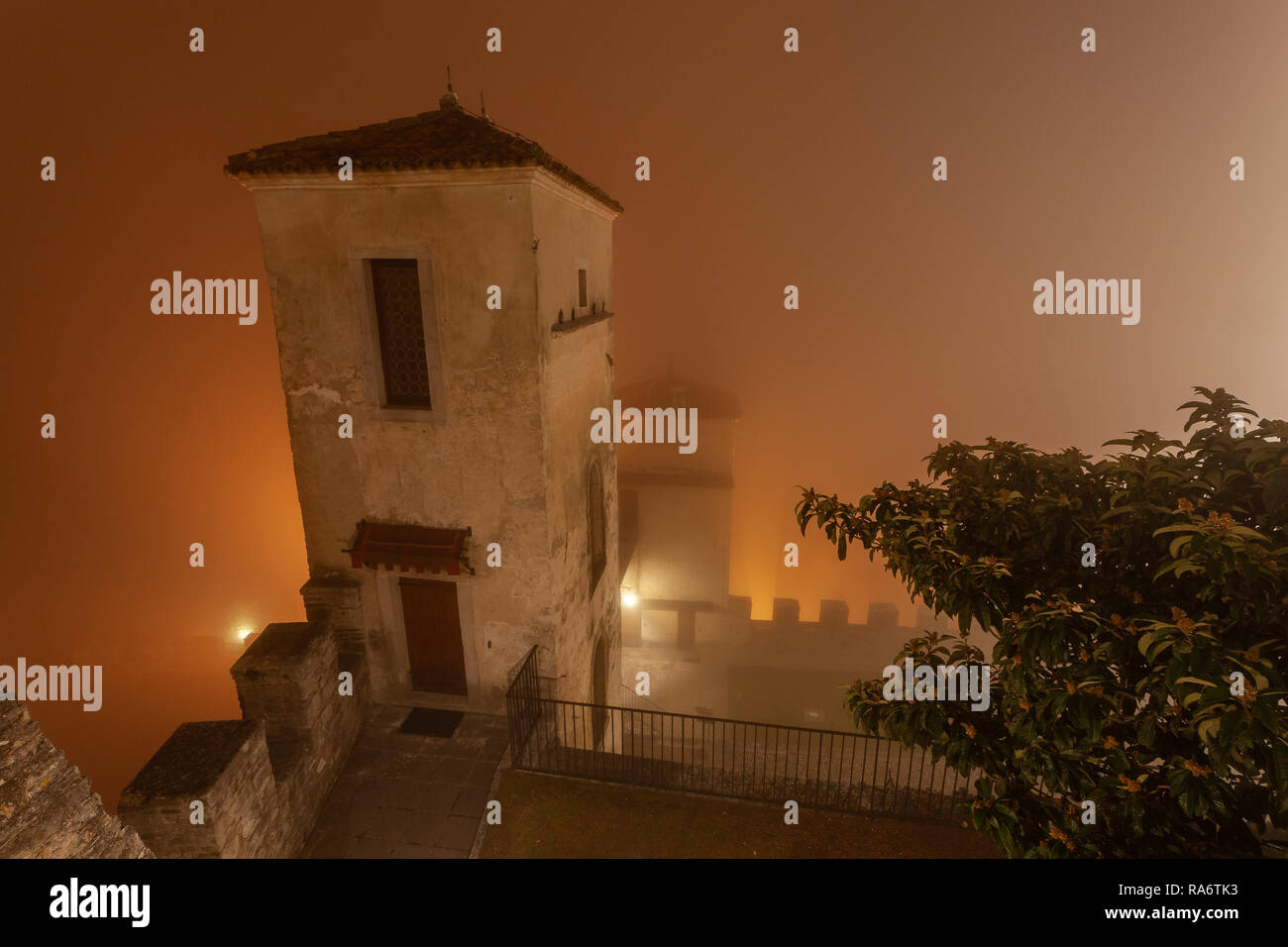 Mauern einer alten Burg im Nebel während eines Winters Nacht eingetaucht, Cison di Valmarino, Italien Stockfoto