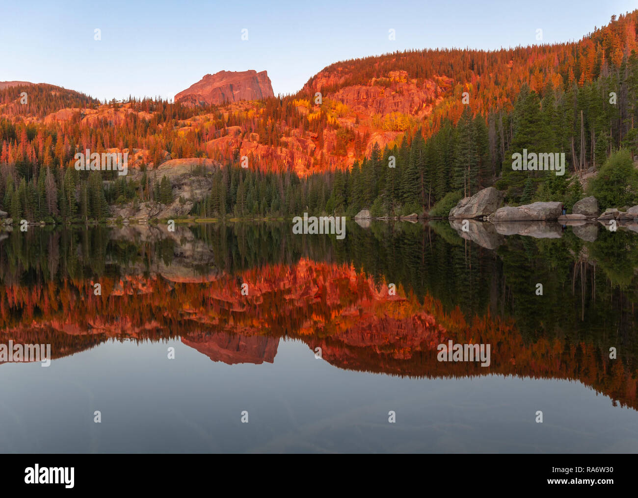 Die Morgensonne hits oben Hallett Peak und den Baumkronen entlang der Ufer des Bear Lake im Rocky Mountain National Park außerhalb von Estes Park, Stockfoto