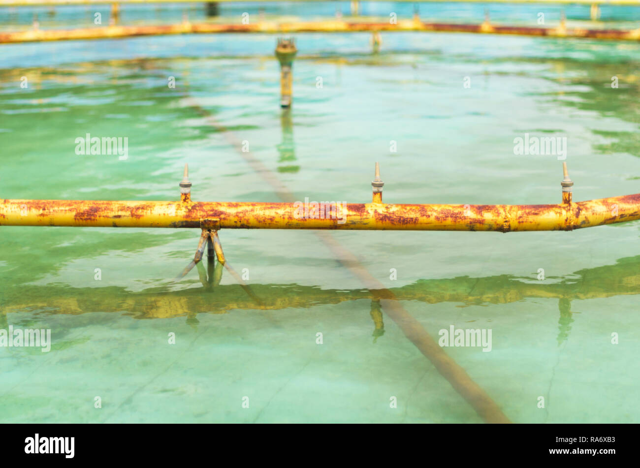 Verrostete gelben Leitungen und Düsen eines Brunnens für die Wartung entleert oder Wartung an einem Sommertag Stockfoto