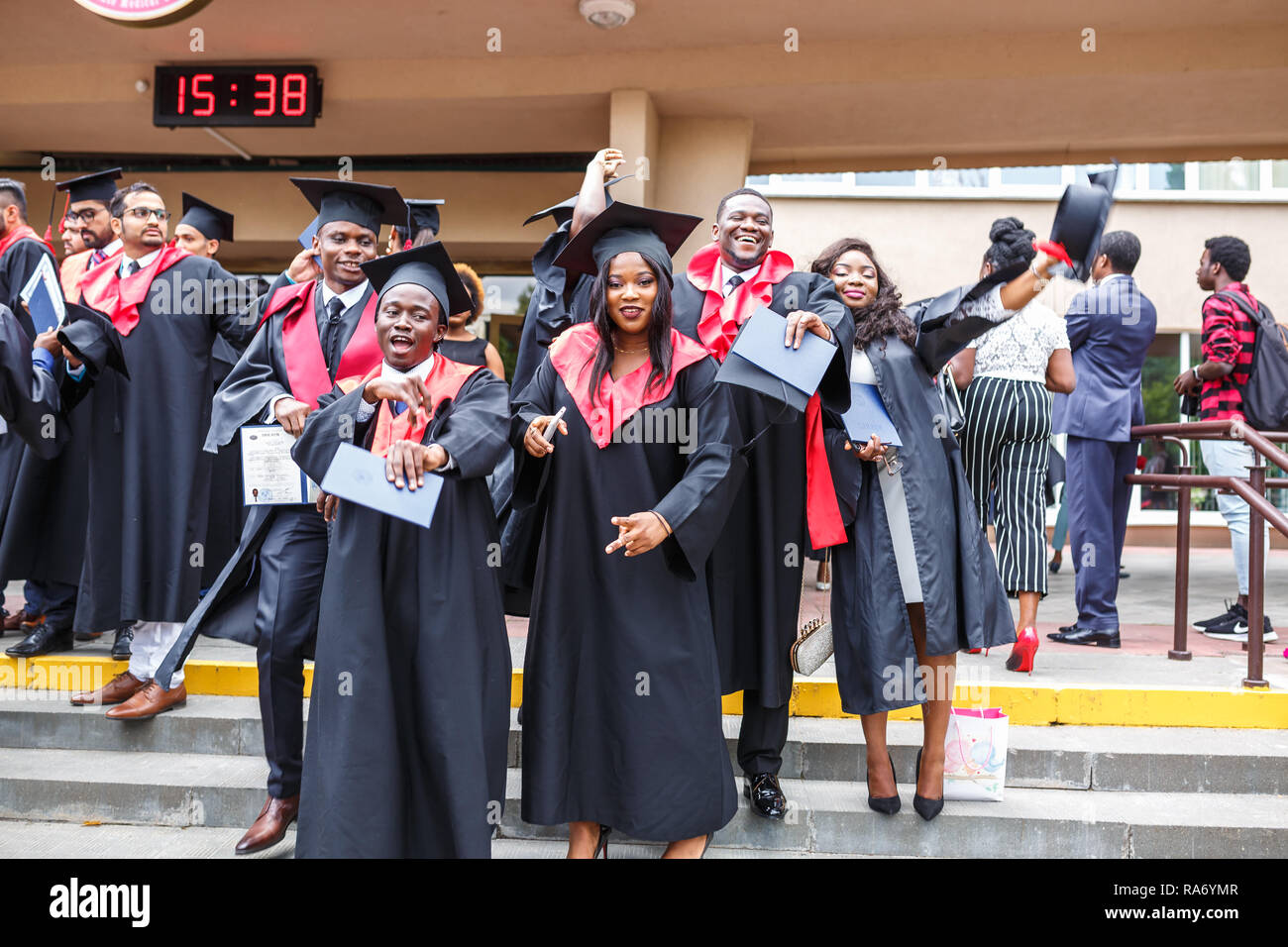 GRODNO, Weißrussland - Juni, 2018: Happy ausländischen afrikanischen Studierenden in eckigen akademische Graduierung Kappen und schwarze Regenmäntel während der Beginn mit d Stockfoto