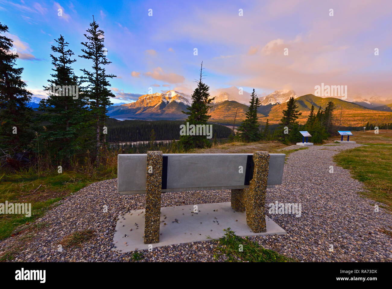 Eine leere Bank für jemanden zu sitzen und den atemberaubenden Sonnenaufgang in den Rocky Mountains von Alberta Kanada genießen Sie warten. Stockfoto