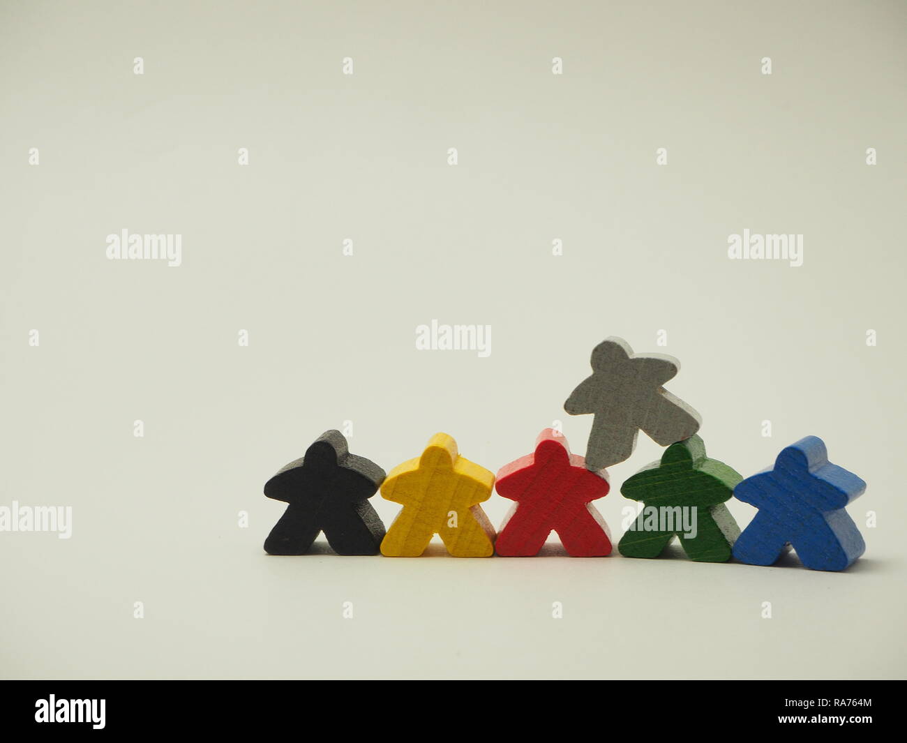 In der Nähe der gelb-schwarz-rot-grau-grün-blaue Meeple Spielsteine gestapelt Stockfoto